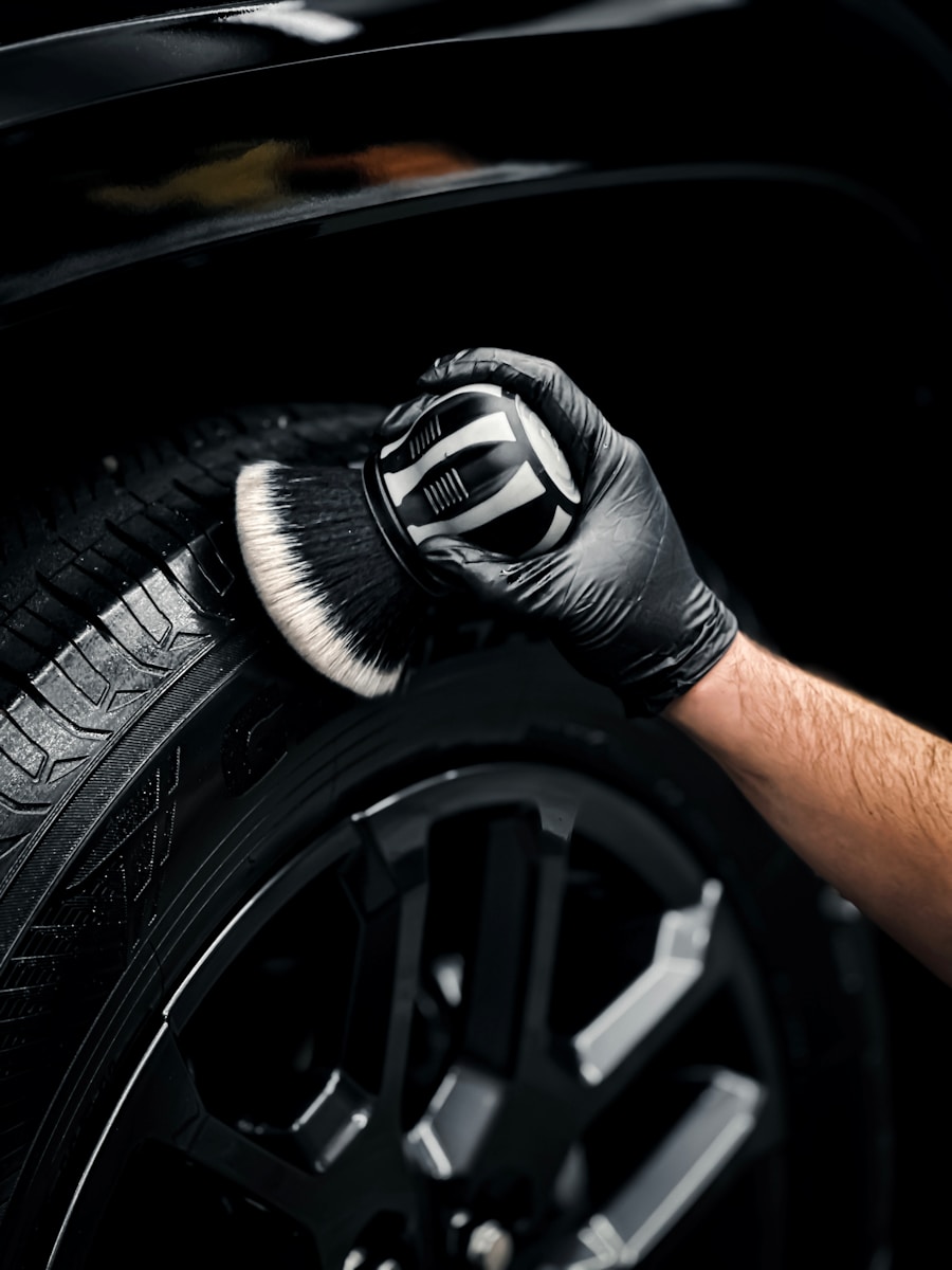 Photo by Zac Nielson a man with a glove on his hand is changing the tire of a car